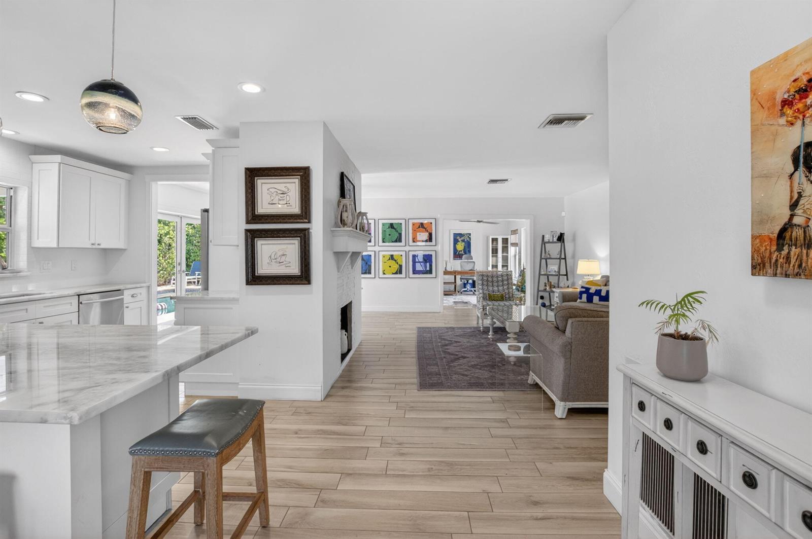 An outdoor kitchen features blue cabinets, patterned tile walls, and a bar with wicker stools — 1501 Dale Lane, Delray Beach FL 33444, DELRAY BEACH, FL