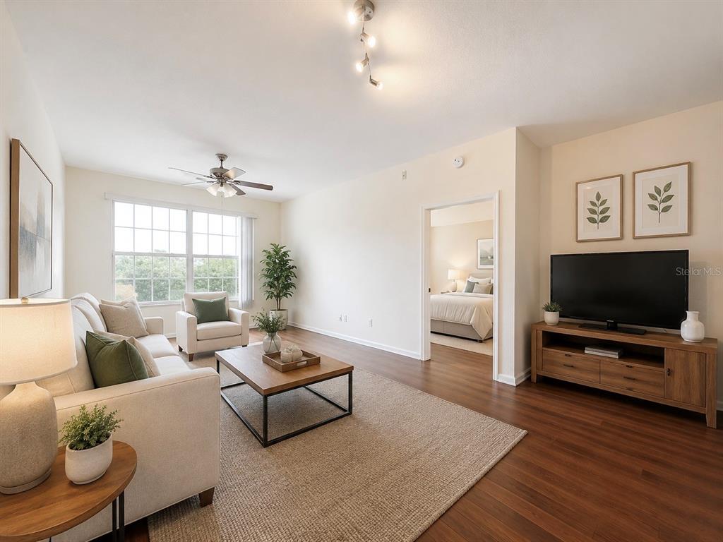 A living room features a sofa, coffee table, television, and an open doorway to a bedroom — 13524 TURTLE MARSH LOOP UNIT 634, ORLANDO, FL