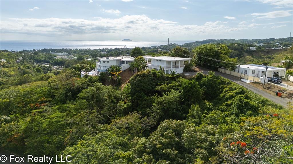 A white, single-story house with a flat roof, black door, and louvered windows — 412 INT CARR BO PUEBLO, RINCON, PR