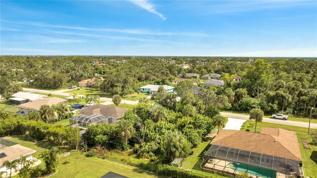 An aerial view shows several suburban houses with swimming pools and lush green vegetation — 18042 LAKE WORTH BOULEVARD, PORT CHARLOTTE, FL
