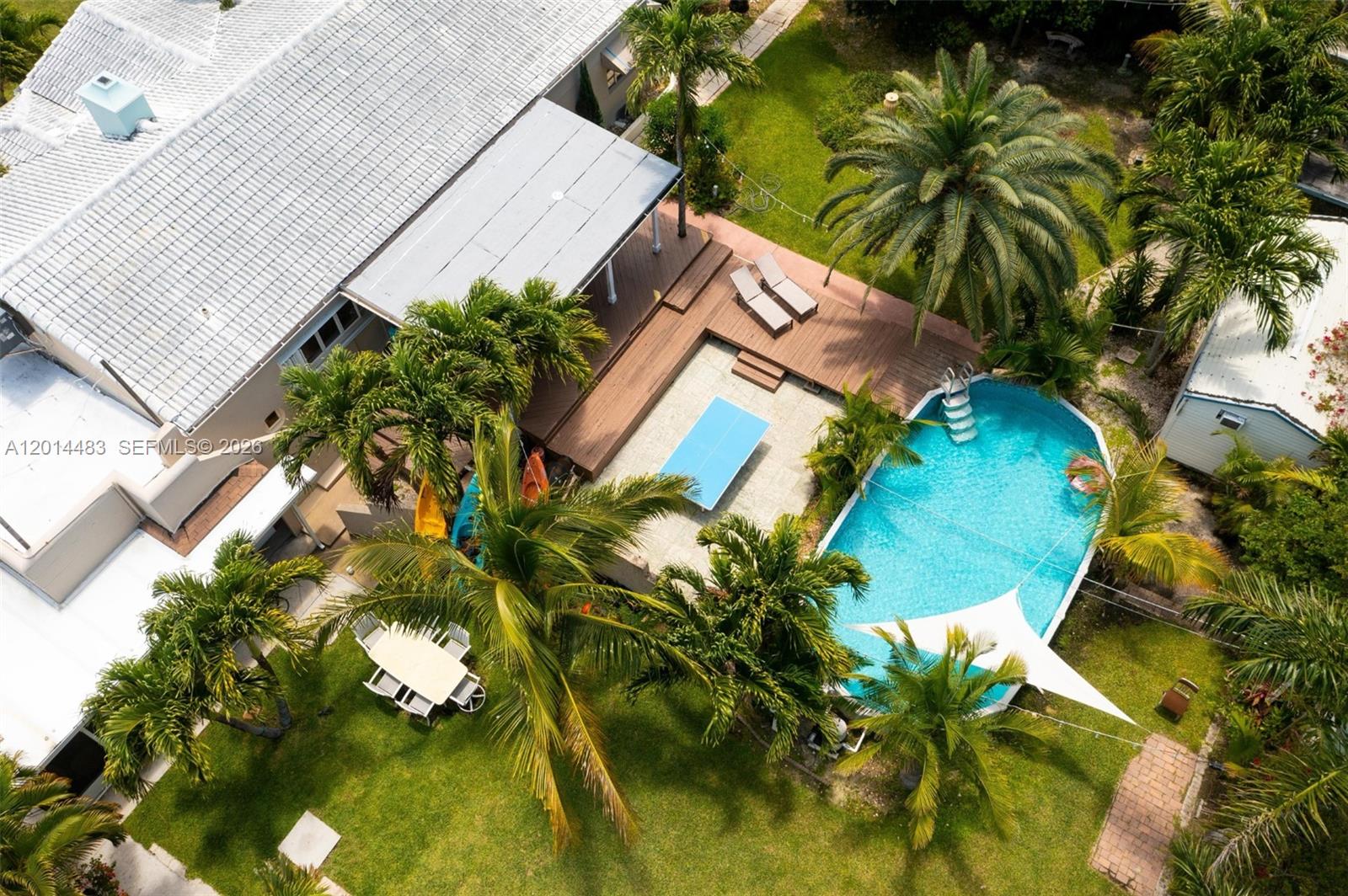 An aerial view shows a house with a wooden deck, swimming pool, and ping-pong table — 701 Hollywood Blvd, Hollywood FL 33019, HOLLYWOOD, FL