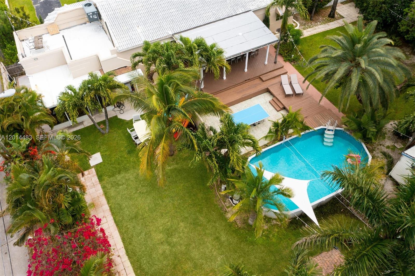 An aerial view shows a backyard with a swimming pool, wooden deck, and palm trees — 701 Hollywood Blvd, Hollywood FL 33019, HOLLYWOOD, FL