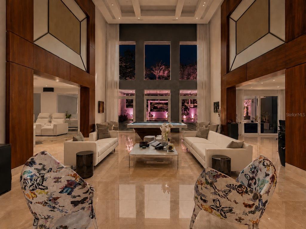 A spacious, high-ceilinged living room features a pool table, white sofas, and patterned armchairs — 276 DORADO BEACH EAST, DORADO, PR