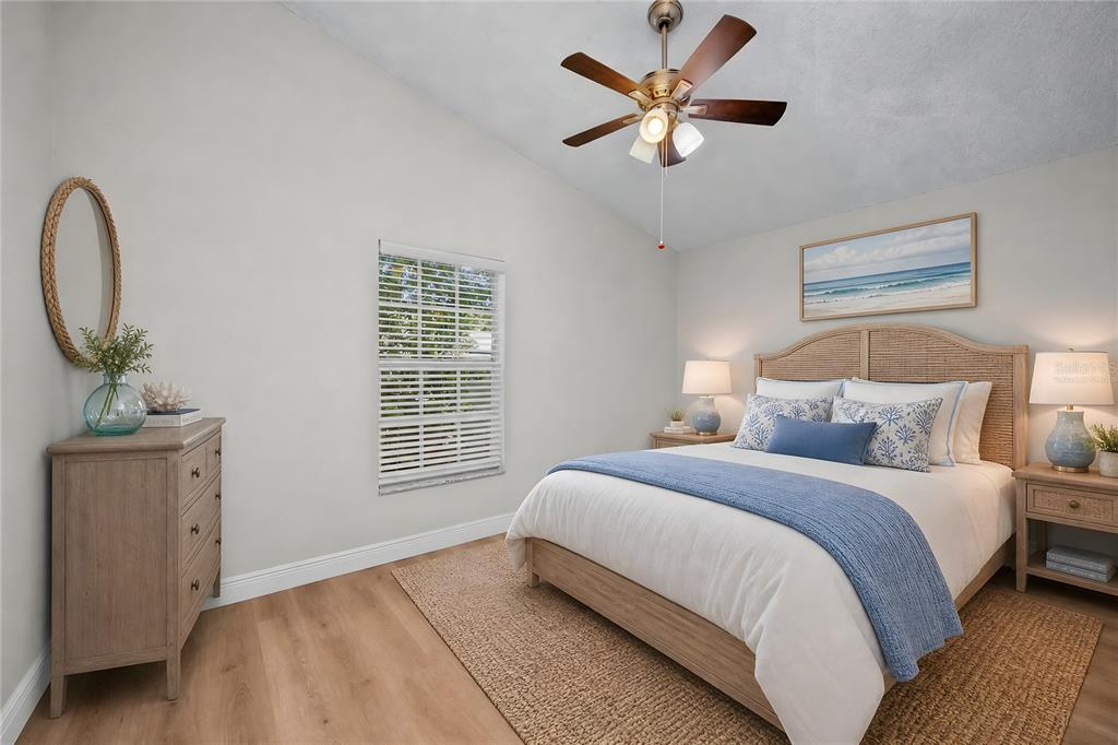 A bedroom features a bed with blue bedding, a ceiling fan, and light wood furniture — 2751 WILSON COURT, PALM HARBOR, FL
