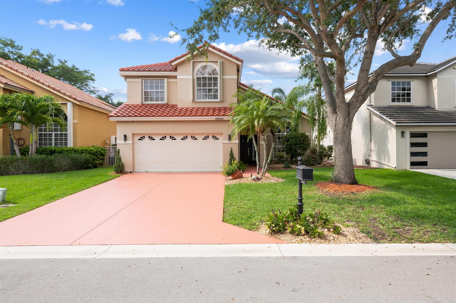 A two-story suburban house with a red tile roof, beige stucco exterior, and a driveway — 10927 La Salinas Circle, Boca Raton FL 33428, BOCA RATON, FL