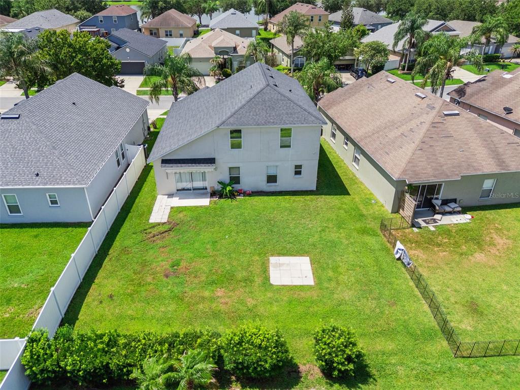 An aerial view shows the backyard of a two-story house with a lawn and patio — 2029 GREAT FALLS WAY, ORLANDO, FL