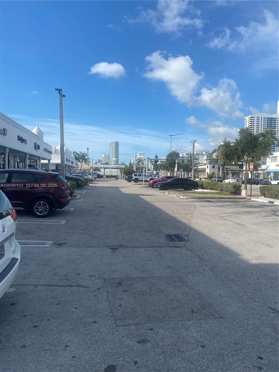 An outdoor parking lot is situated between commercial buildings under a bright blue sky — 1527 Alton Rd, Miami Beach FL 33139, MIAMI BEACH, FL