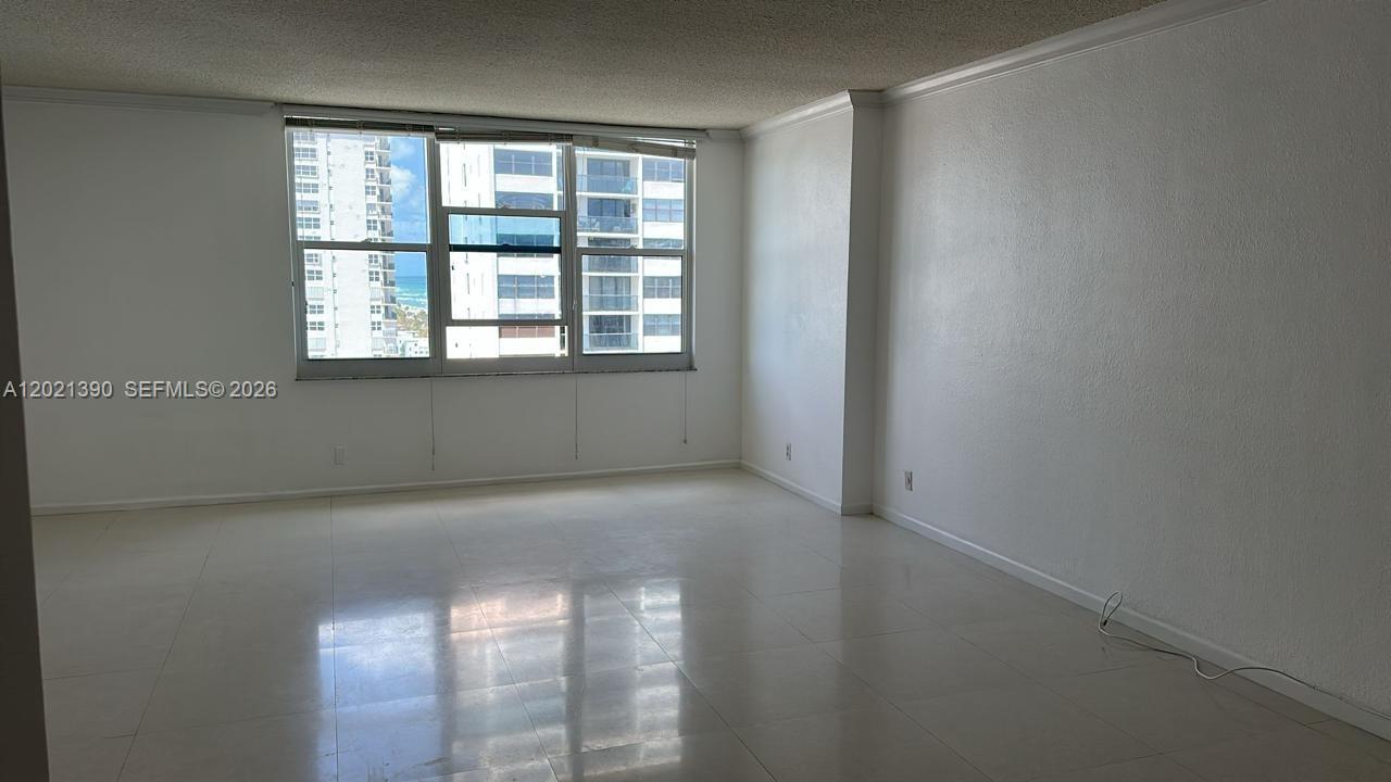 An empty room with white walls, light tile flooring, and a window overlooking buildings — 2501 S Ocean Dr # 1603, Hollywood FL 33019, HOLLYWOOD, FL