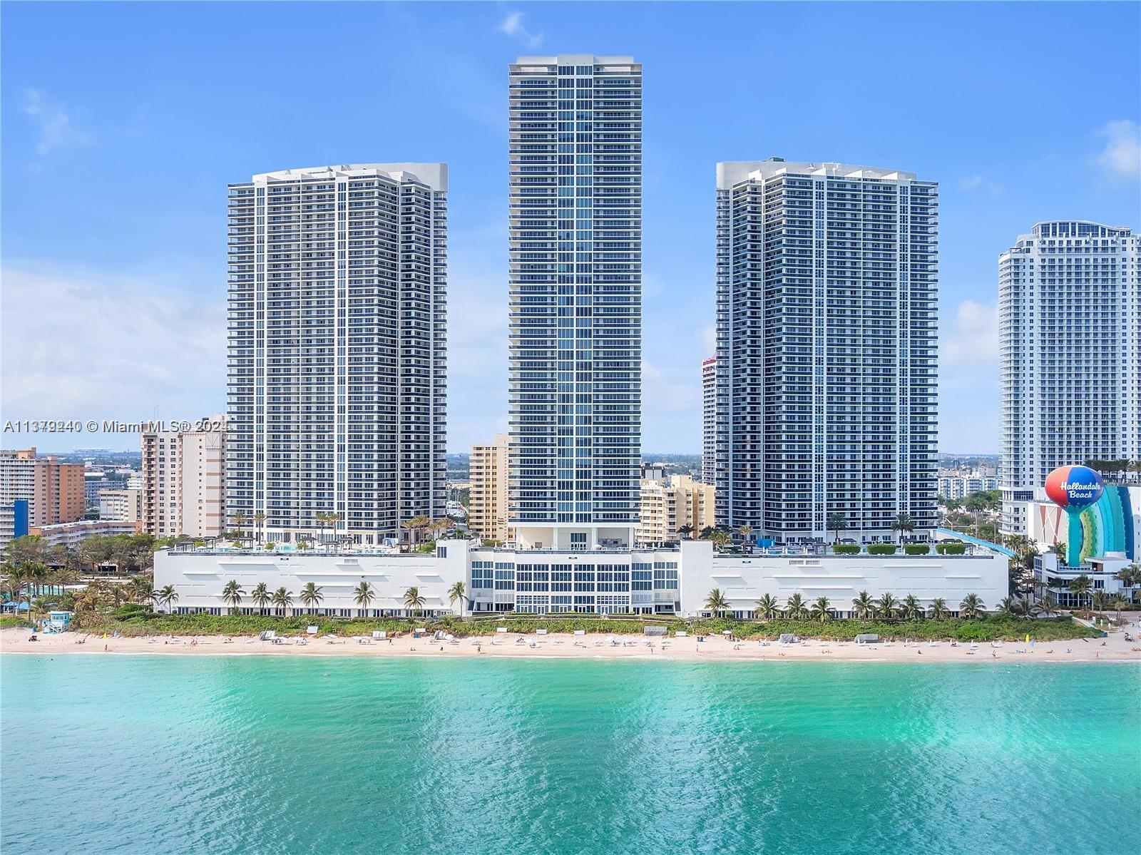 An aerial view of three tall residential towers situated directly on a sandy beach — 1830 S Ocean Dr # 2010, Hallandale Beach FL 33009, HALLANDALE BEACH, FL