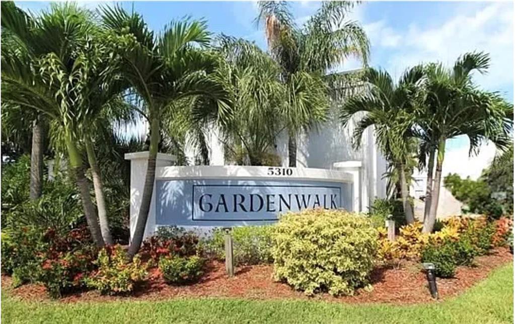 A sign for Gardenwalk stands in a landscaped garden with palm trees and shrubs — 5310 26TH STREET W UNIT 304, BRADENTON, FL