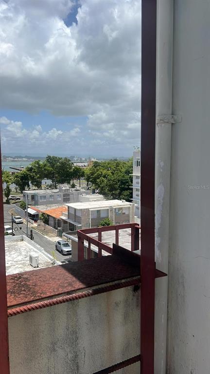 An elevated view from a balcony overlooking a street, nearby buildings, and a distant bay — 708 Ave  Fernandez Juncos MIRAMAR, SAN JUAN, PR