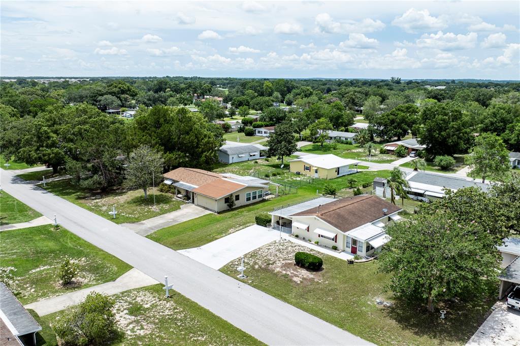 An aerial view shows several single-story residential houses surrounded by trees and grassy yards — 9035 SW 102ND PLACE, OCALA, FL