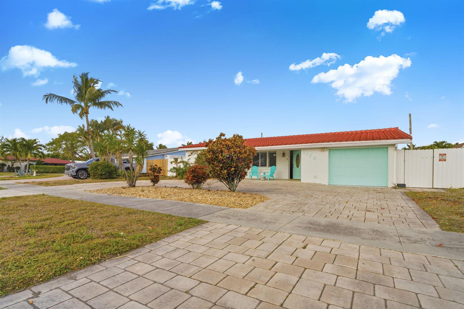 A single-story house with a red tile roof, light blue garage door, and paved driveway — 1123 SE 2nd Avenue, Deerfield Beach FL 33441, DEERFIELD BEACH, FL