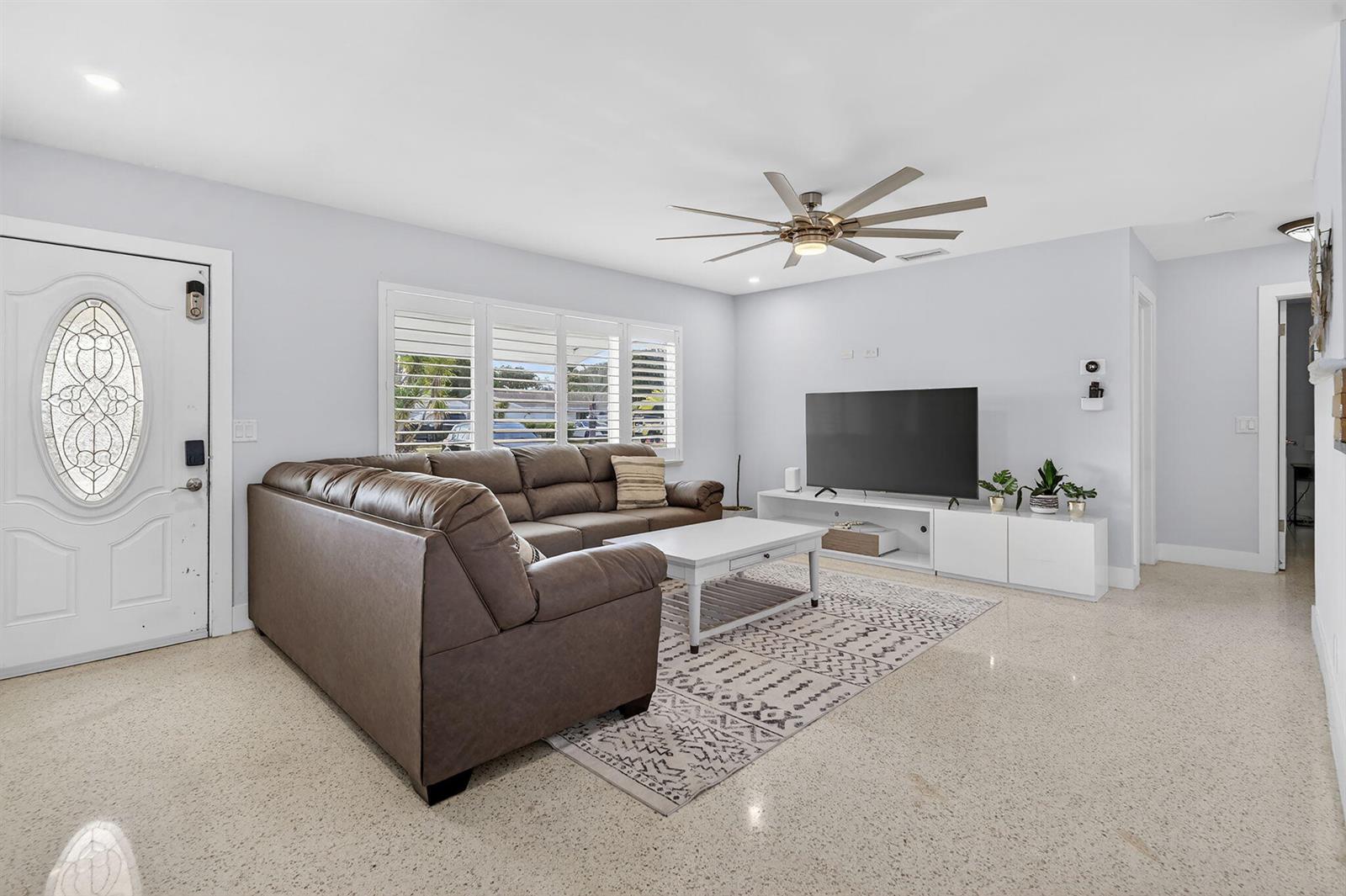 A living room features a brown sectional sofa, a white coffee table, and a television — 1123 SE 2nd Avenue, Deerfield Beach FL 33441, DEERFIELD BEACH, FL