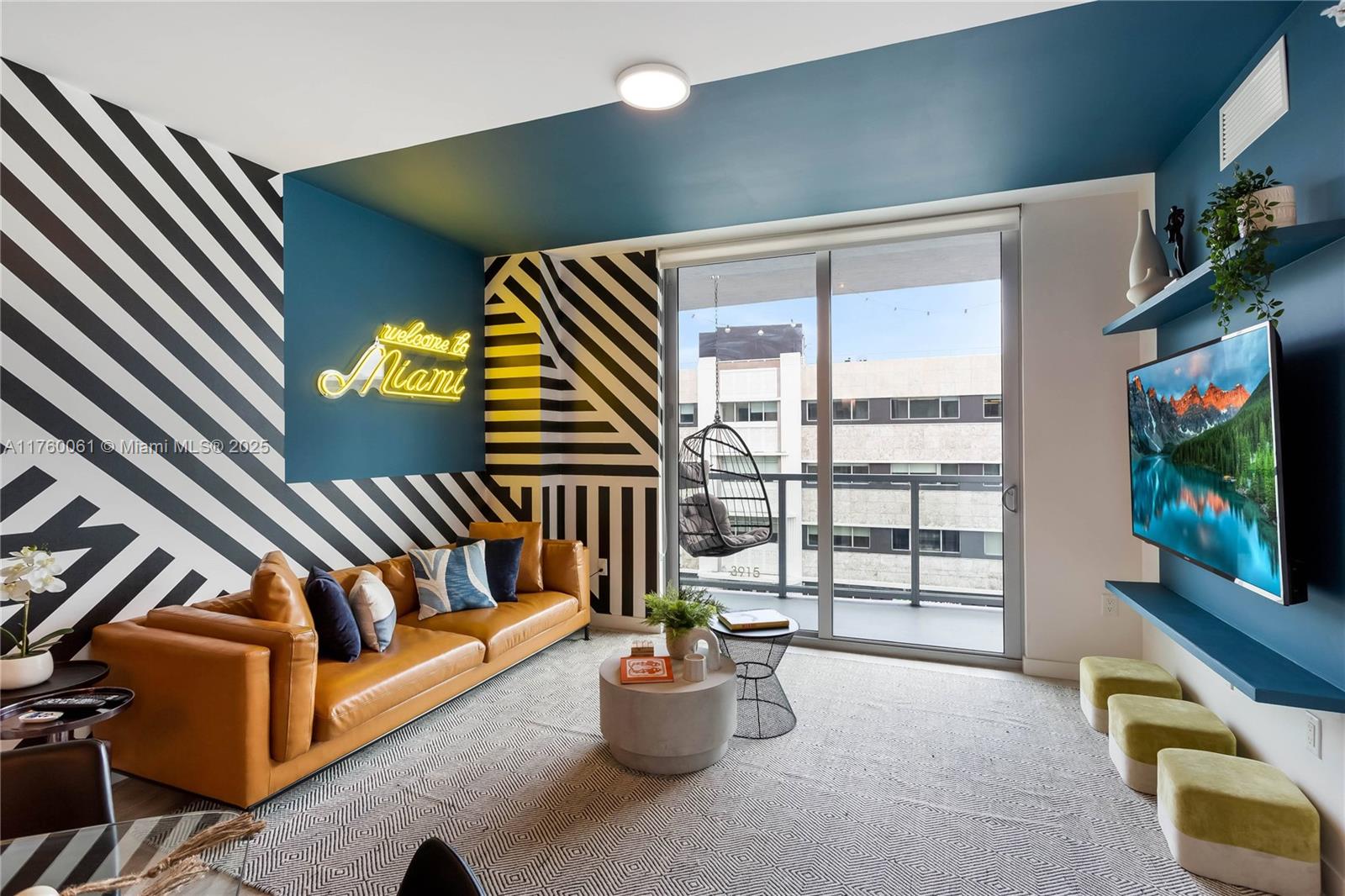 A living room features a tan leather sofa, striped accent walls, and a neon sign — 3900 Biscayne Blvd # 314, Miami FL 33137, MIAMI, FL