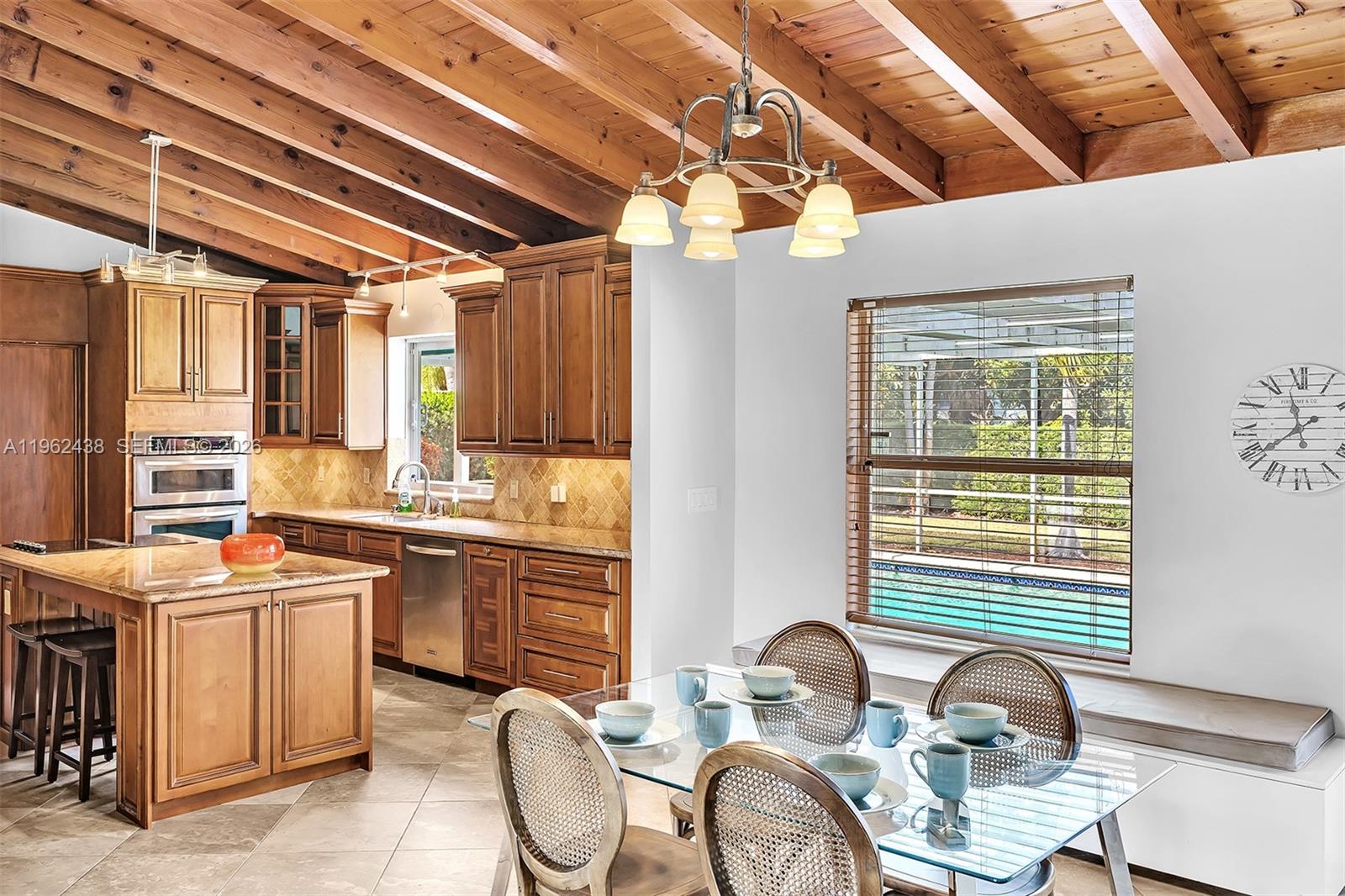 A kitchen and dining area feature wood-beamed ceilings, wood cabinetry, and a glass-topped table — 3437 Buchanan St, Hollywood FL 33021, HOLLYWOOD, FL