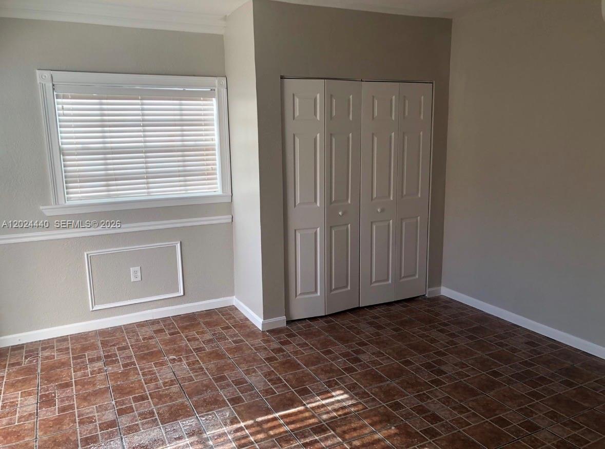 A room with tile flooring, a window with blinds, and a white bi-fold closet door — 17649 SW 142nd Ct, Miami FL 33177, MIAMI, FL