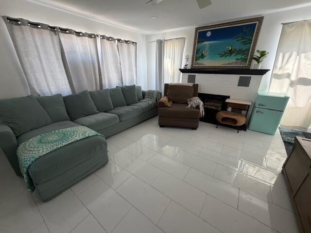 A living room features a large sectional sofa, a fireplace, and light-colored tile flooring — 1015 S K Street, FL 33460, FL
