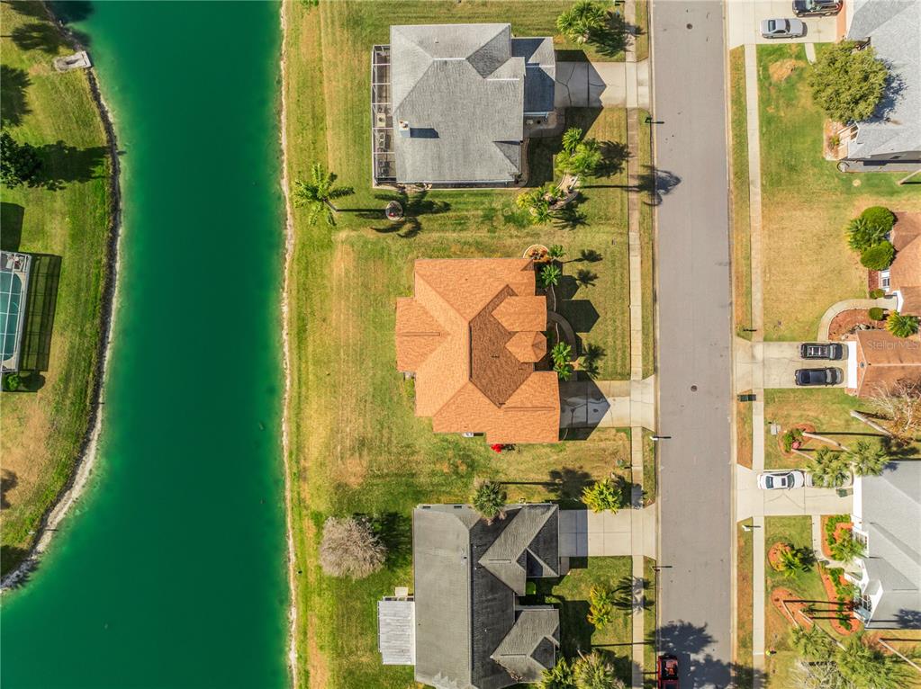 An aerial view shows three houses situated along a narrow canal and a residential street — 343 ALEATHA DRIVE, DAYTONA BEACH, FL