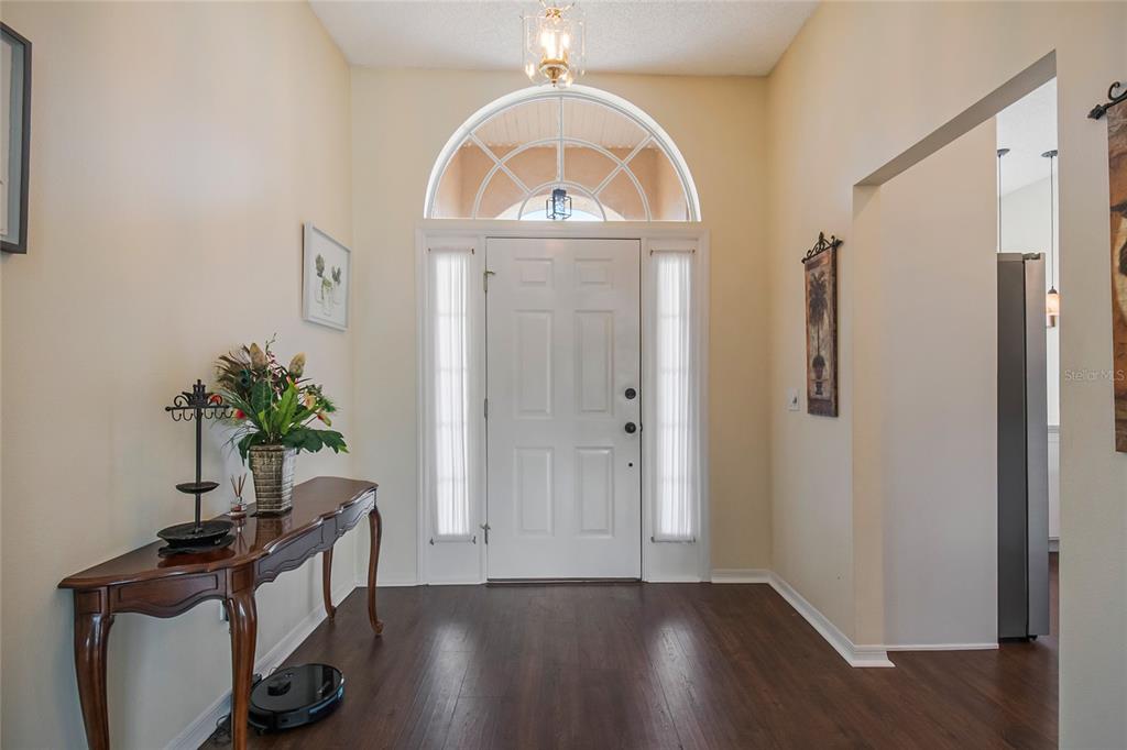 A foyer features dark wood flooring, a white front door with sidelights, and an arched transom — 343 ALEATHA DRIVE, DAYTONA BEACH, FL