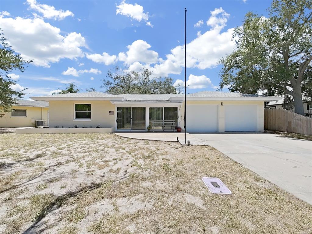 A single-story house with a light-colored brick exterior, a two-car garage, and a front patio — 5 N KEYSTONE DRIVE, CLEARWATER, FL