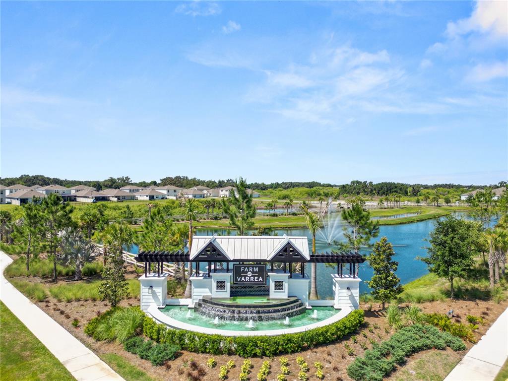 An aerial view of a community entrance sign with a fountain and a pond — 3830 SUNFLOWER FIELD PLACE, PLANT CITY, FL