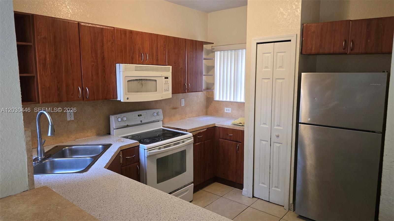A kitchen features wood cabinets, stainless steel appliances, and light-colored countertops — 671 SW 10th St, Florida City FL 33034, FLORIDA CITY, FL