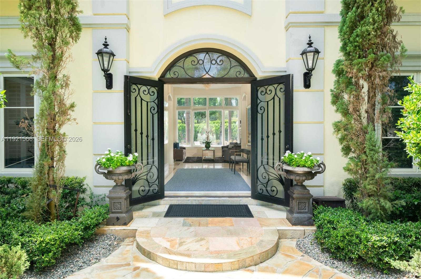 An arched doorway with black iron-framed glass doors opens into a bright, tiled foyer — 8010 Ponce De Leon Rd, Miami FL 33143, MIAMI, FL