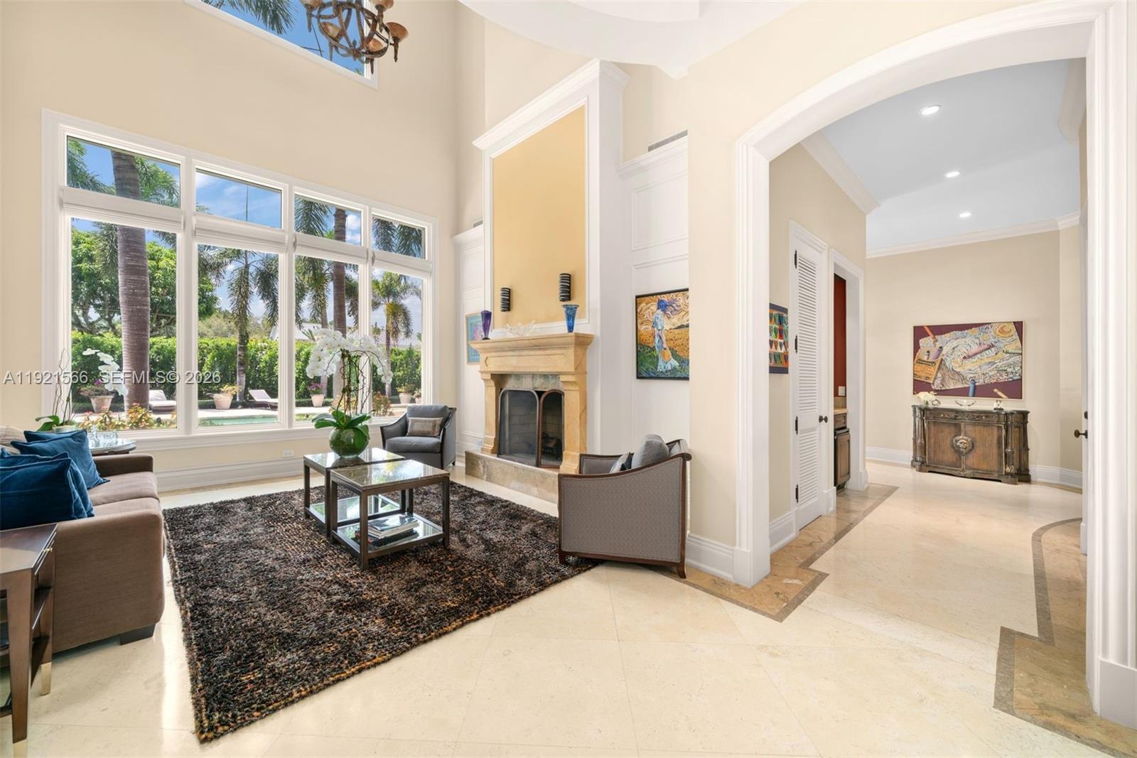 A living room features a stone fireplace, high ceilings, large windows, and tile flooring — 8010 Ponce De Leon Rd, Miami FL 33143, MIAMI, FL