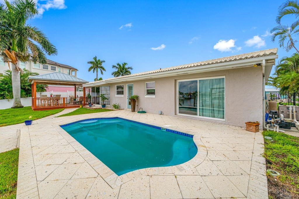 A backyard features a swimming pool, a patio, a gazebo, and a single-story house exterior — 530 79TH STREET S, ST PETERSBURG, FL