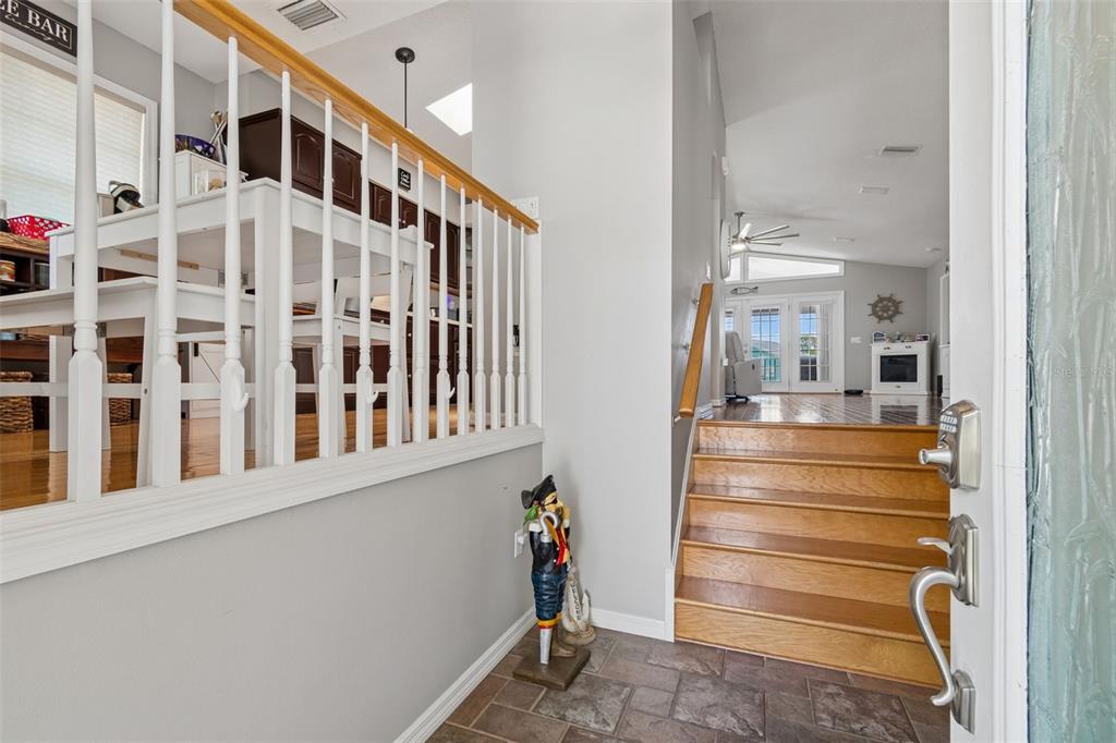 A covered wooden deck features outdoor furniture and a ceiling fan overlooking a canal view — 6211 BAYSIDE DRIVE, NEW PORT RICHEY, FL