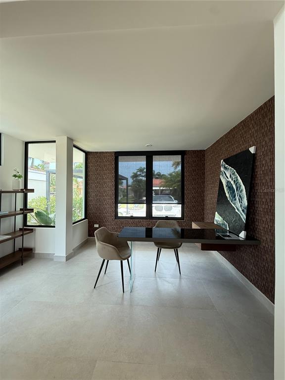 A modern home office features a glass-topped desk, textured brown wallpaper, and large windows — 241 CAMINO DEL JAGUEY, DORADO, PR