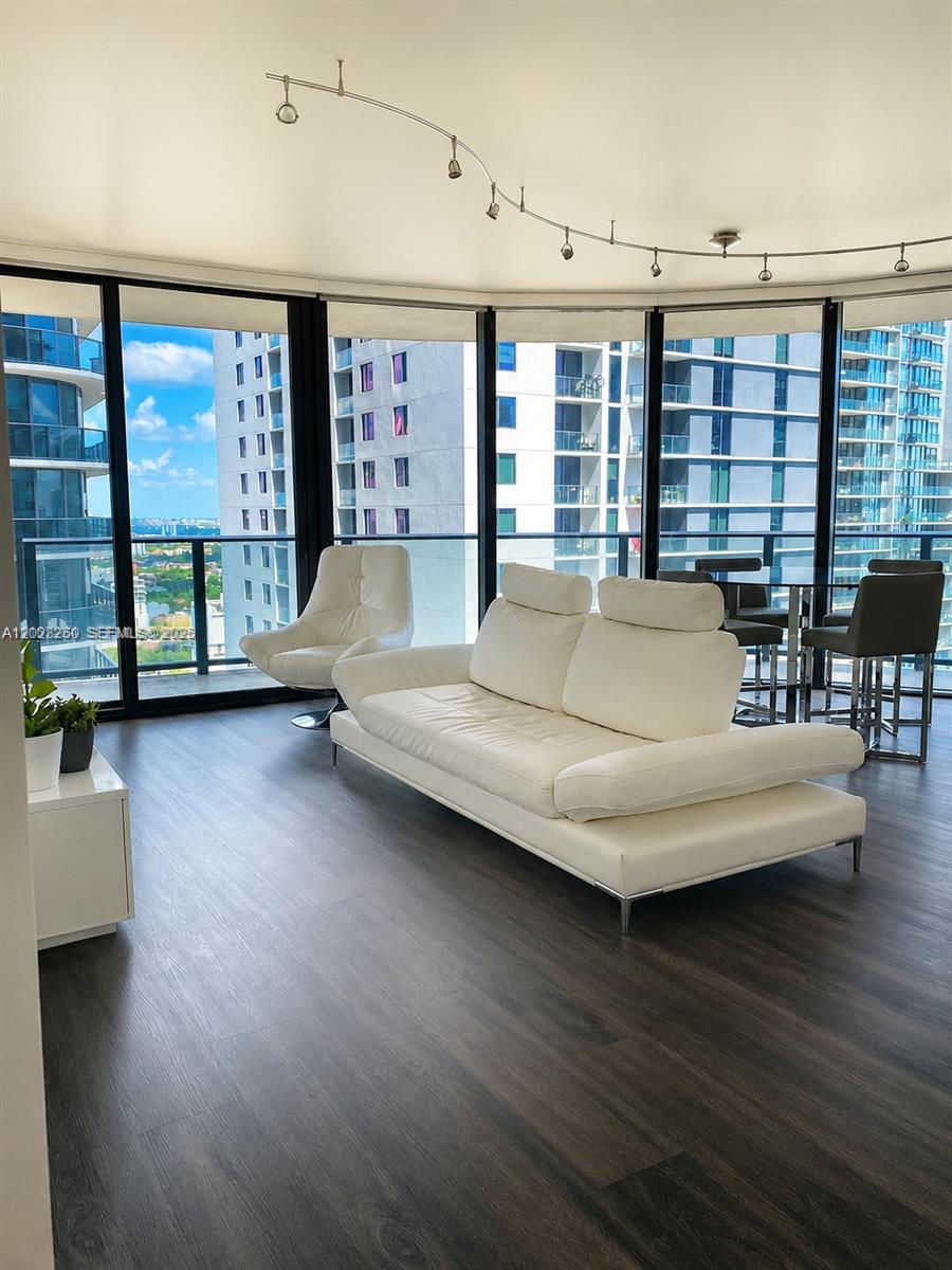 A modern living room features a white sofa, an accent chair, and floor-to-ceiling windows — 45 SW 9th St # 2908, Miami FL 33130, MIAMI, FL
