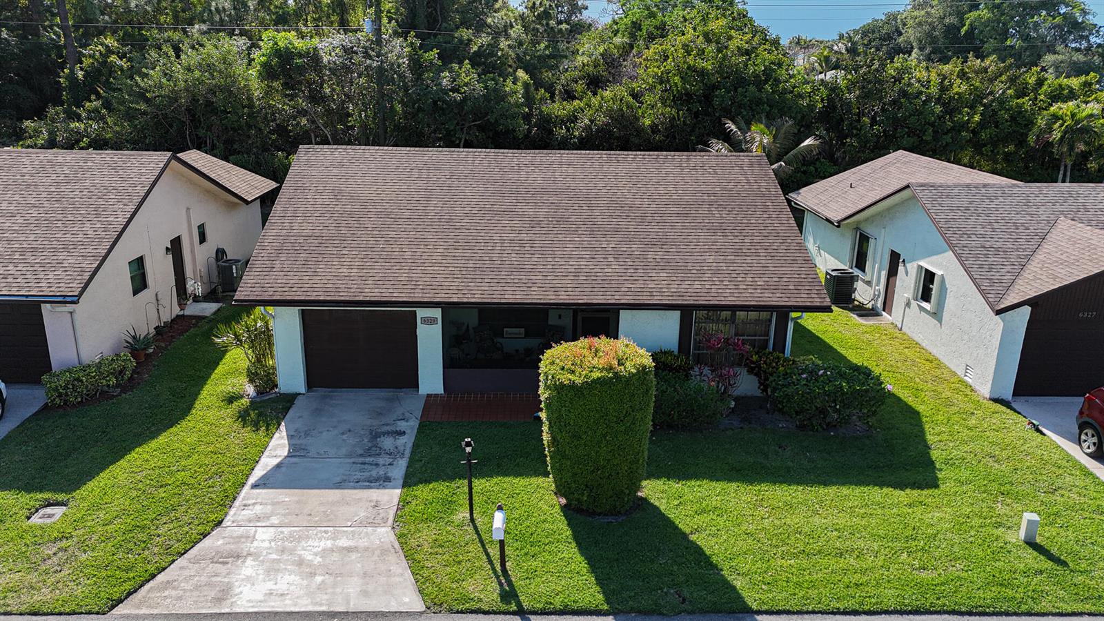 An aerial view shows a single-story house with a brown roof, garage, and front lawn — 6329 Tall Cypress Circle, FL 33463, FL