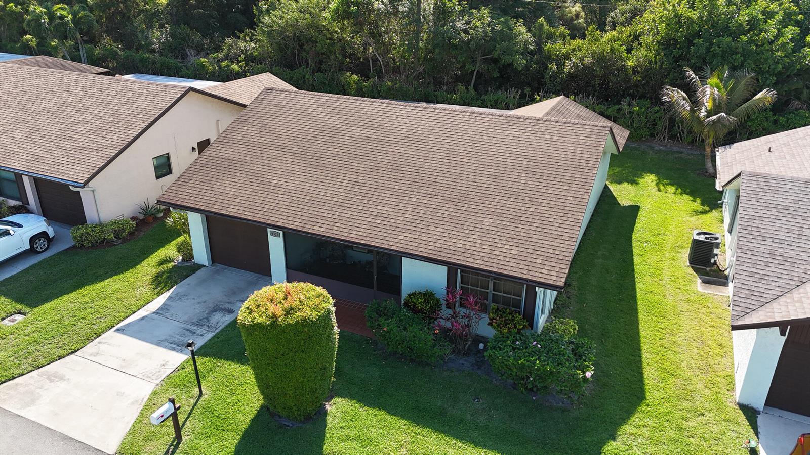 An aerial view shows a single-story house with a brown shingled roof and driveway — 6329 Tall Cypress Circle, FL 33463, FL
