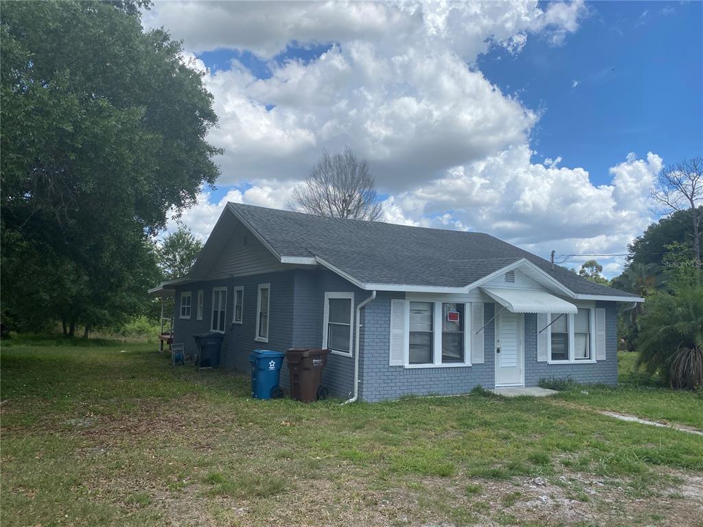 A single-story gray brick house with a gabled roof and white shutters — 431 S MIAMI STREET, LAKE WALES, FL
