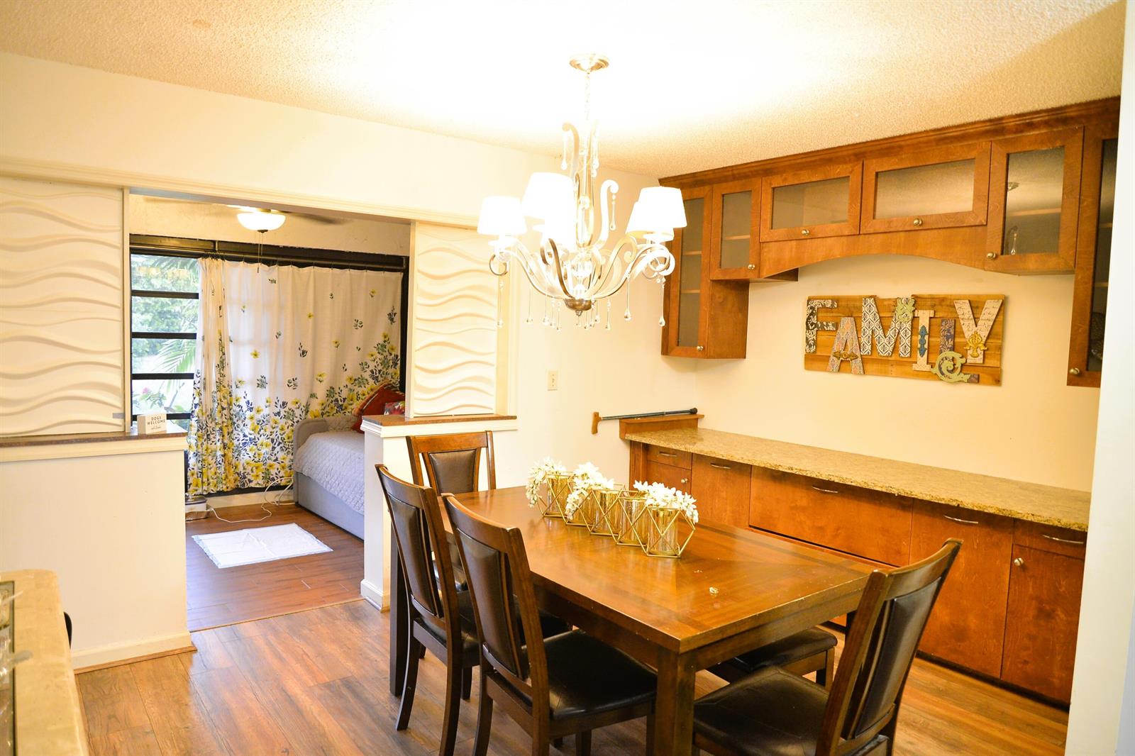 A dining room with a wooden table, chandelier, and built-in cabinetry against a wall — 10054 Eaglewood Road # B, Boynton Beach FL 33436, BOYNTON BEACH, FL