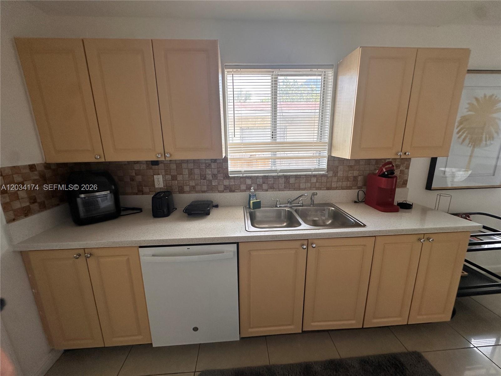 A kitchen features light wood cabinets, a double sink, and a white dishwasher — 404 NW 2nd Ave # A, Hallandale Beach FL 33009, HALLANDALE BEACH, FL
