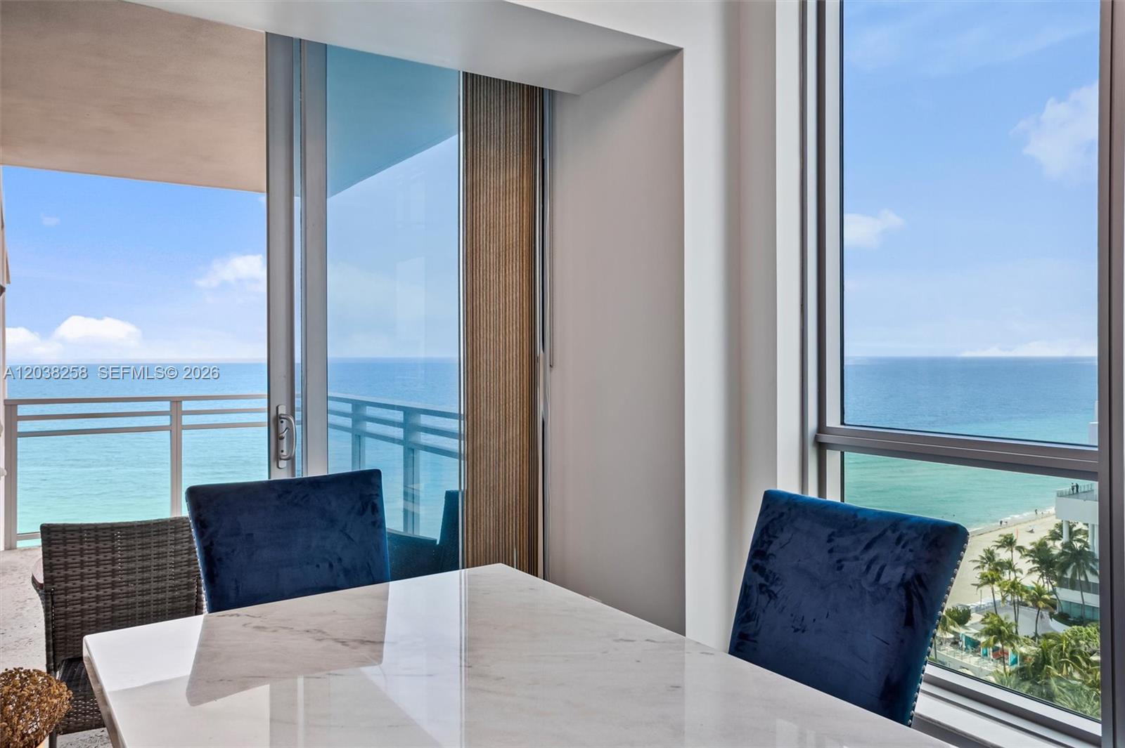A dining area features a marble table, blue velvet chairs, and floor-to-ceiling ocean views — 3535 S Ocean Dr # 1703, Hollywood FL 33019, HOLLYWOOD, FL