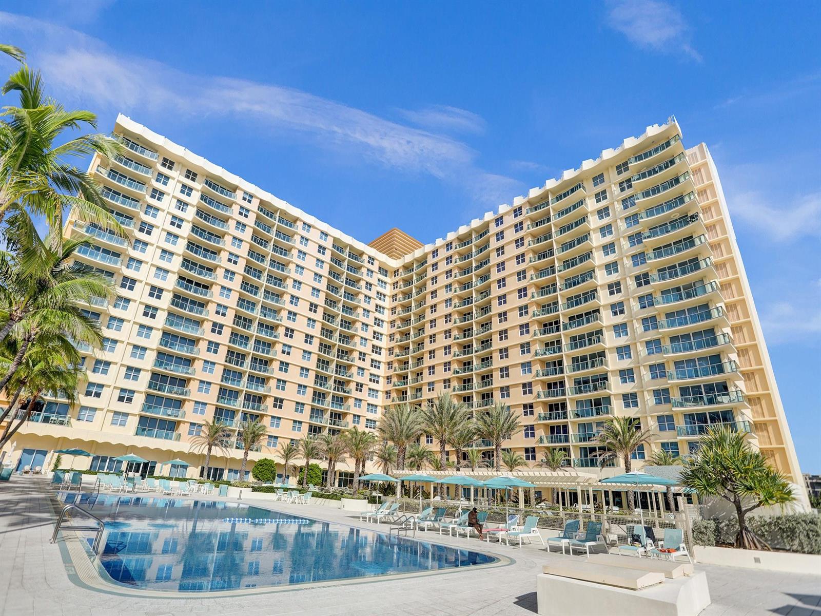 A large, multi-story tan resort building overlooks a swimming pool with lounge chairs and umbrellas — 2501 S Ocean Drive # 338, Hollywood FL 33019, HOLLYWOOD, FL