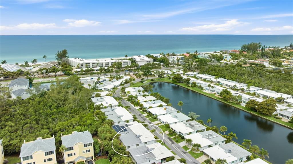An aerial view shows a residential community with a lake near the ocean — 602 SPANISH DRIVE S UNIT 115, LONGBOAT KEY, FL