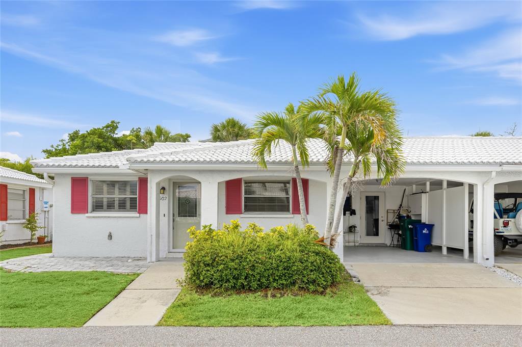 A white single-story house with red shutters, a palm tree, and a carport — 602 SPANISH DRIVE S UNIT 115, LONGBOAT KEY, FL