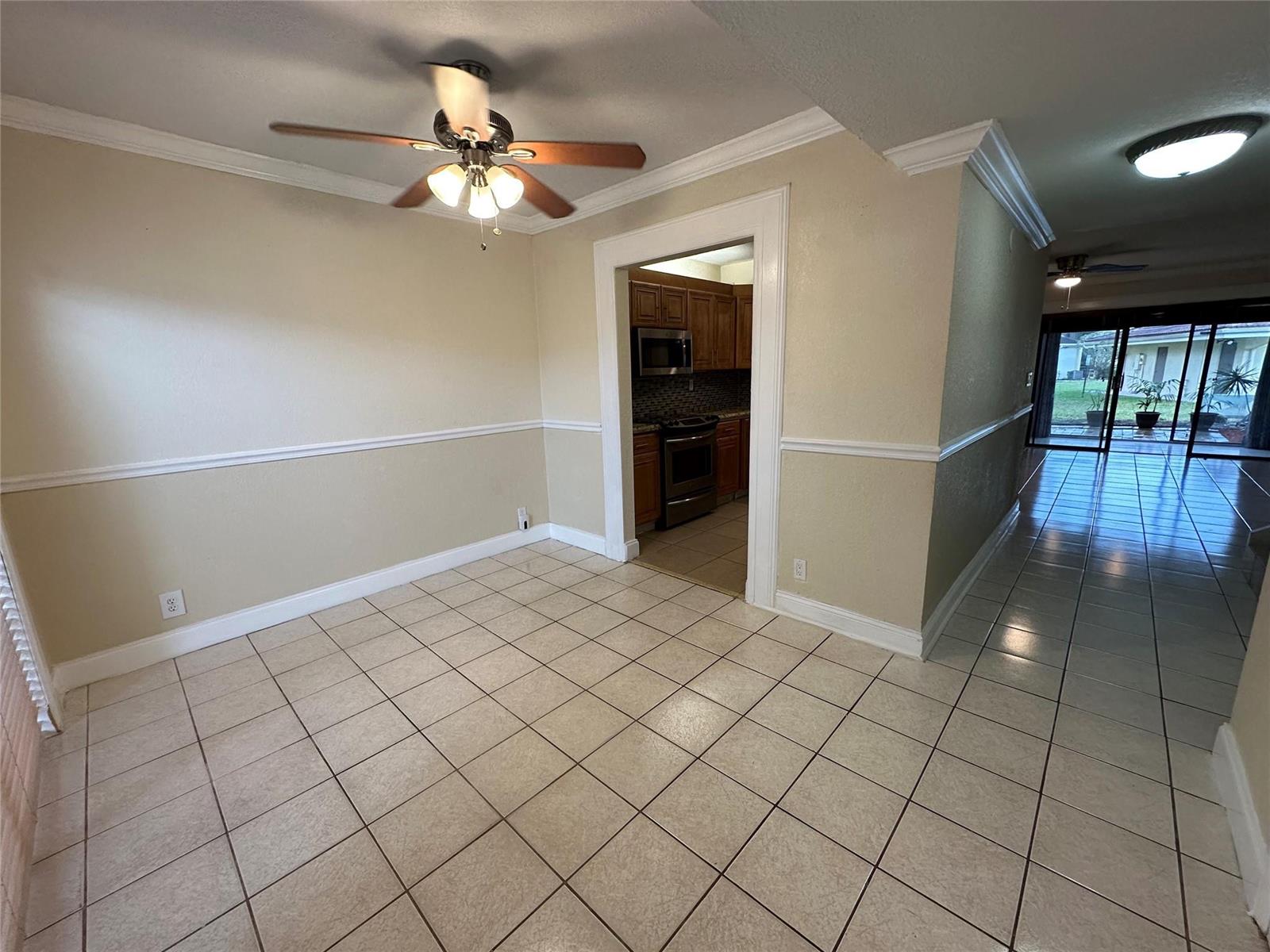 A dining area with tile flooring and a ceiling fan leads into a kitchen — 22435 SW 61st Way # 124, Boca Raton FL 33428, BOCA RATON, FL