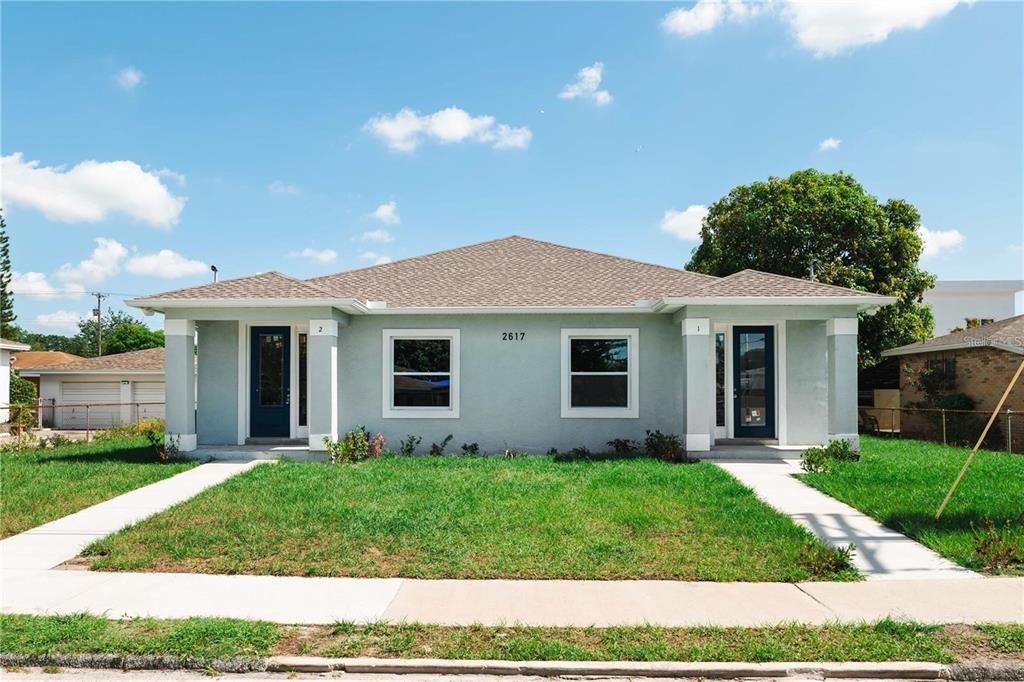 A single-story duplex with a light gray exterior, two front doors, and a grassy yard — 2617 W SAINT JOSEPH STREET UNIT 2, TAMPA, FL