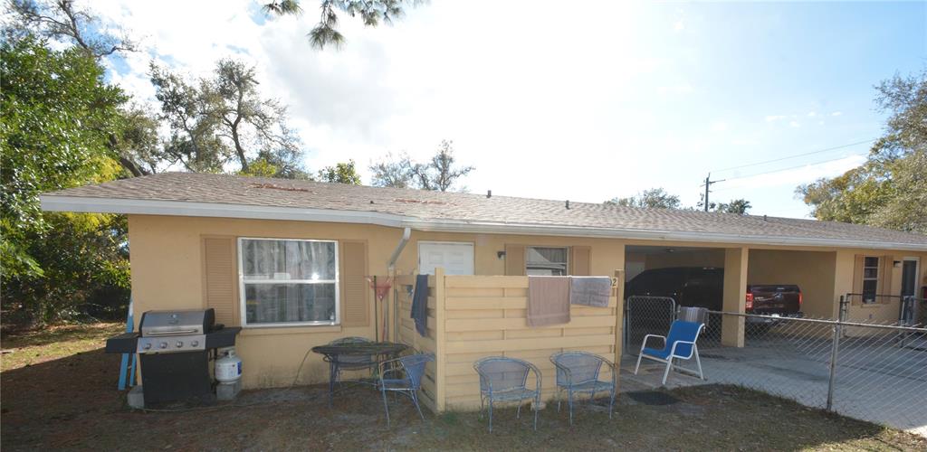 The exterior of a single-story house features a tan facade, a carport, and a patio area — 2100 9TH STREET, SARASOTA, FL