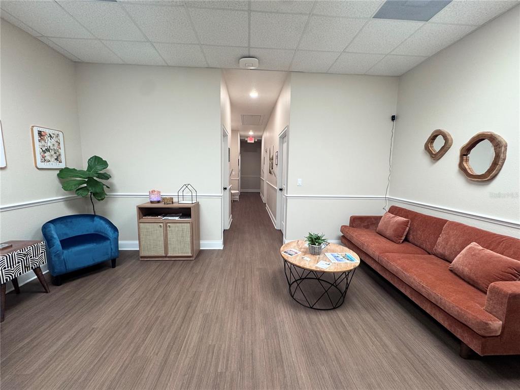 A waiting room features a rust-colored sofa, a blue armchair, and a central hallway — 129 E 13TH STREET UNIT B, ST CLOUD, FL