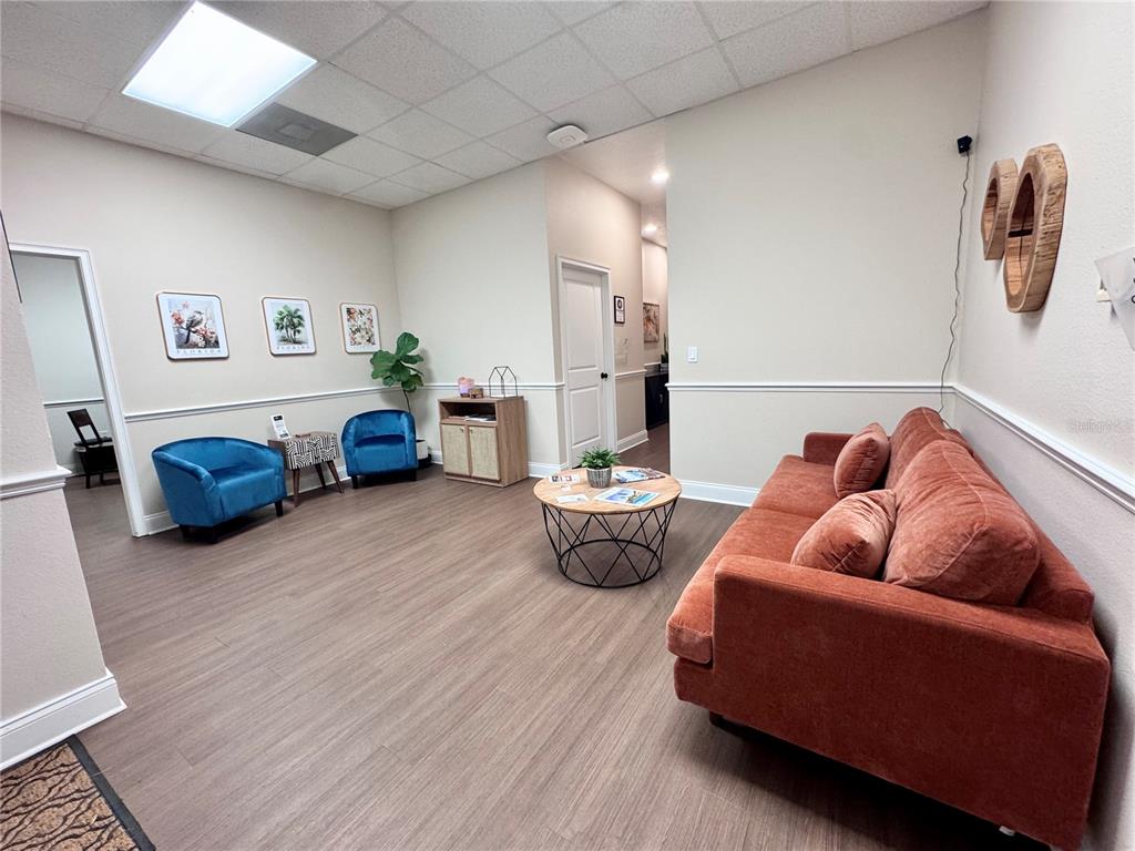 A waiting room features a rust-colored sofa, two blue armchairs, and a round coffee table — 129 E 13TH STREET UNIT B, ST CLOUD, FL