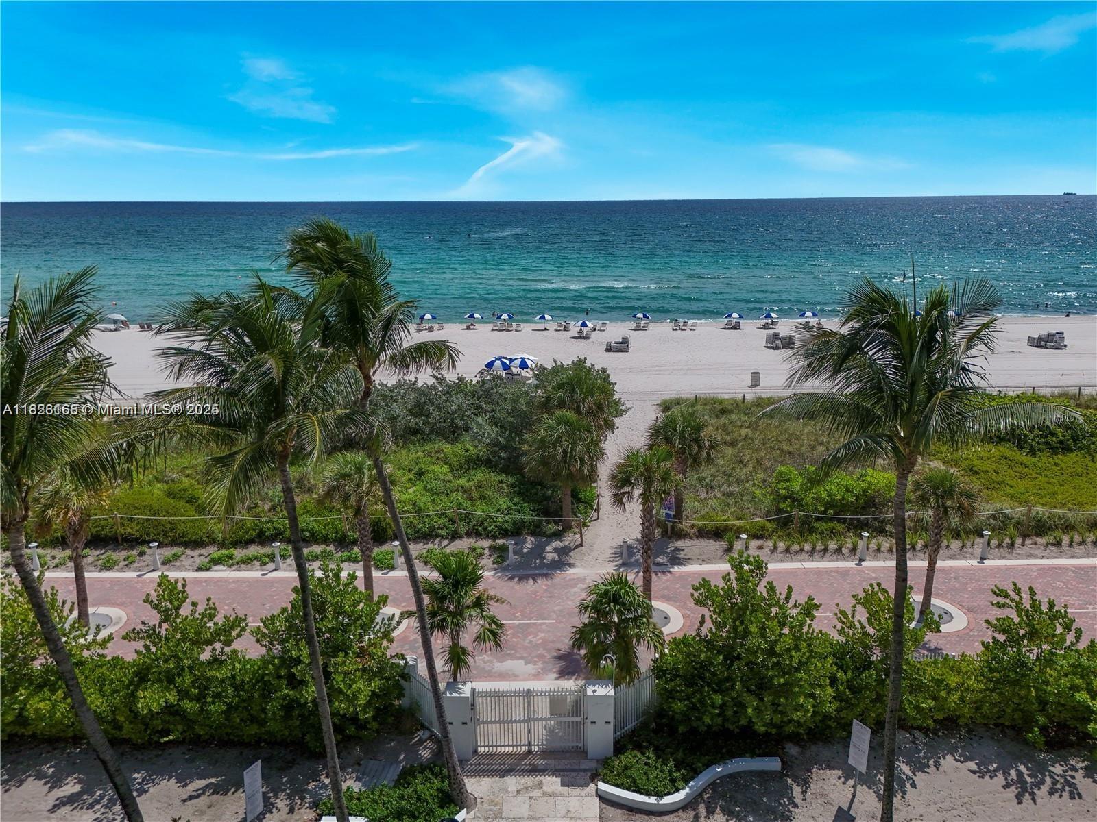 An elevated view shows a gated path leading through greenery to a sandy beach — 5151 Collins Ave # 535, Miami Beach FL 33140, MIAMI BEACH, FL