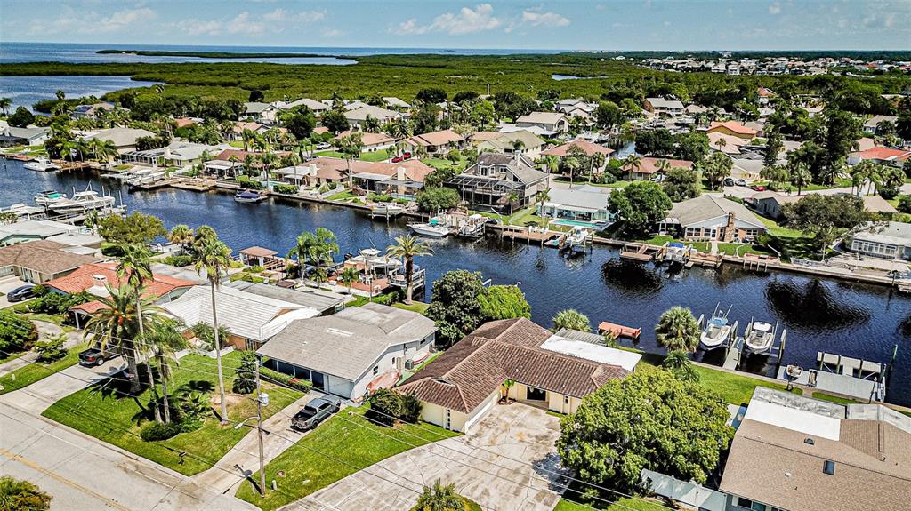 An aerial view of waterfront houses with private docks and boats along a canal — 4149 FLORAMAR TERRACE, NEW PORT RICHEY, FL