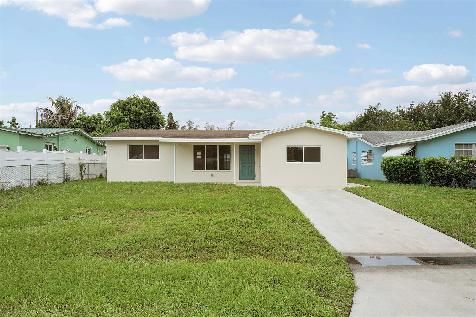 A single-story house with a cream exterior, teal front door, and a concrete driveway — 4142 Kirkland Lane, Lake Worth FL 33461, LAKE WORTH, FL